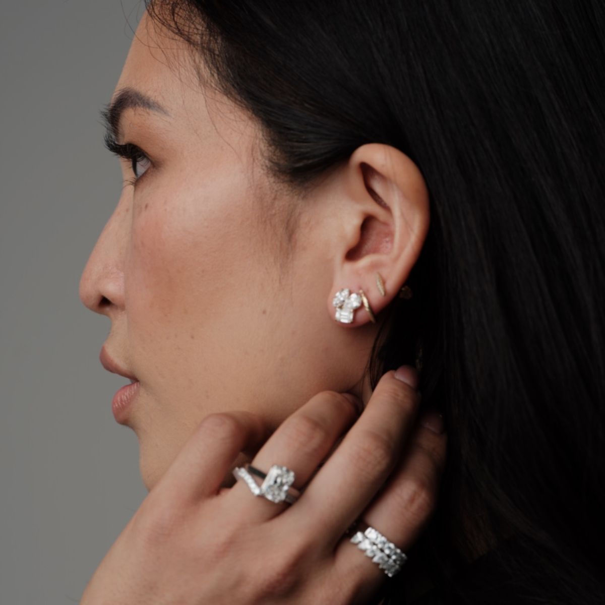 Side profile of a woman wearing custom earrings and diamond rings by Seema Jewelry and Co.
