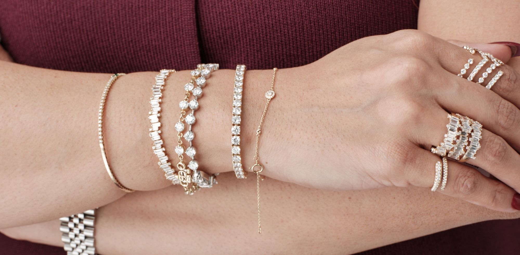 Close-up of hands adorned with diamond bracelets and rings by Seema Jewelry and Co., highlighting bespoke craftsmanship.