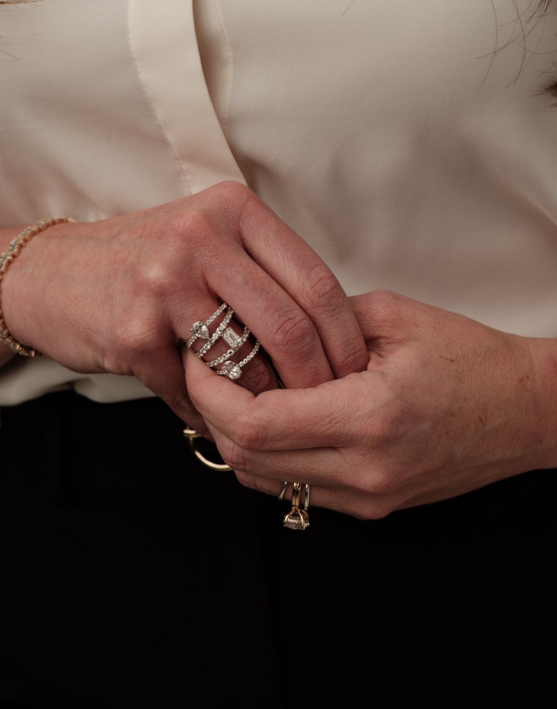 Close-up of hands wearing custom engagement rings by Seema Jewelry and Co.