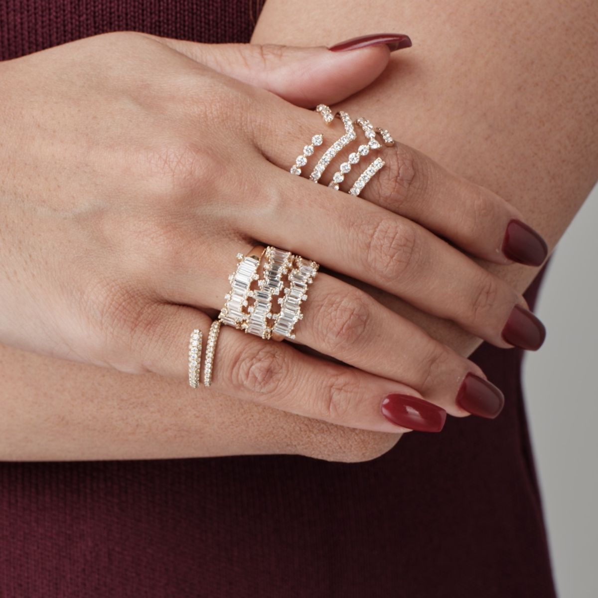 Close-up of hands adorned with gold rings and diamond accents from Seema Jewelry and Co.